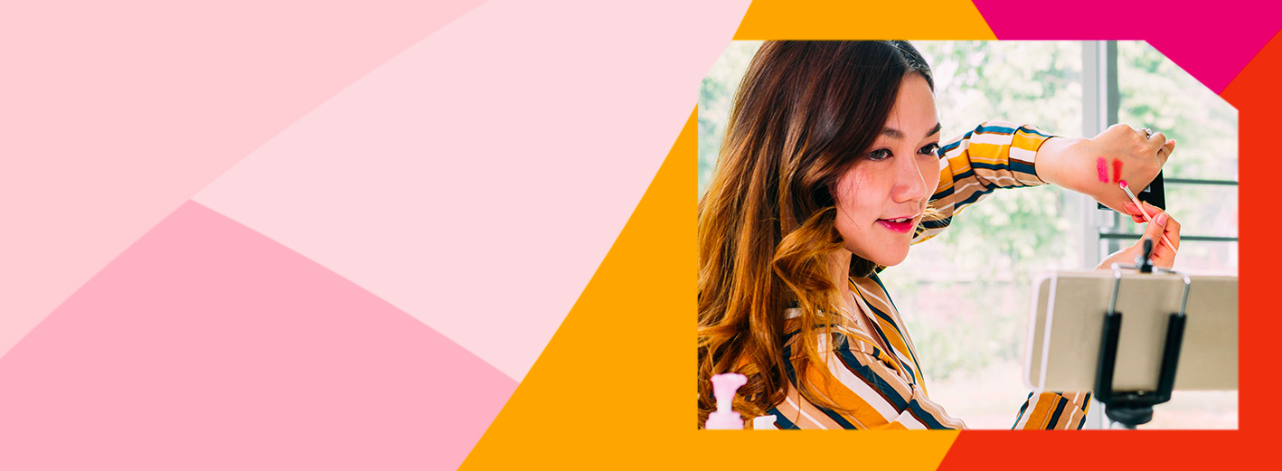 A woman demonstrating makeup application on her hand toward a smartphone on a tripod. An Independent Beauty Consultant offers trusted advice and personalized service.