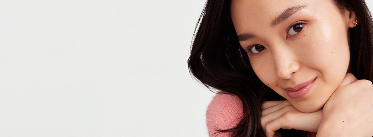 An Asian female model wearing a simple makeup look showing off her glowing skin