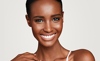 A smiling black woman with glowing even skin