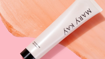 Pink tube of Mary Kay® Extra Emollient Night Cream moisturizer for dry skin on pink product rub background