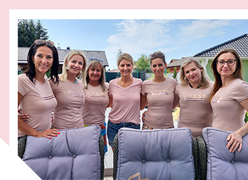 Image of a group of women outside smiling in a row wearing matching pink t-shirts