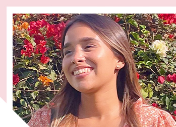 Image of a woman smiling outside in the sunlight