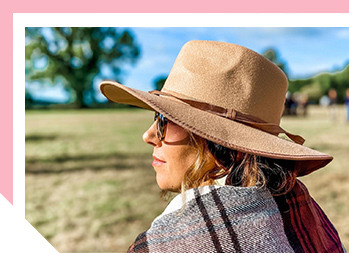 Image of woman wearing a hat outside looking to the distance