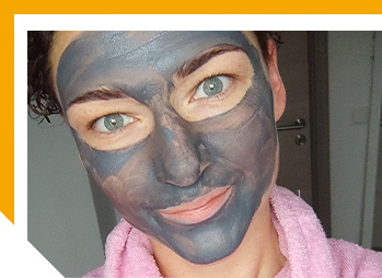 Image of woman with charcoal skin care mask applied to her face