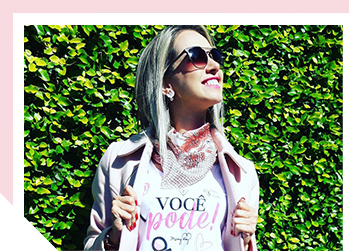 Image of woman smiling outside wearing sunglasses looking up at the sunlight