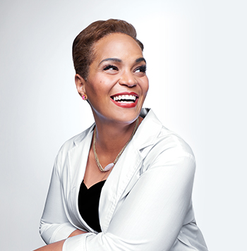 Dr. Michelle Hines Director of Product Formulation and Global Upstream Research a smiling black female scientist in a lab coat in a scientific setting