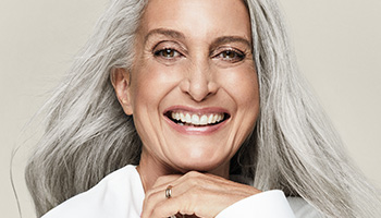 A smiling mature white woman with gray hair and beautiful skin