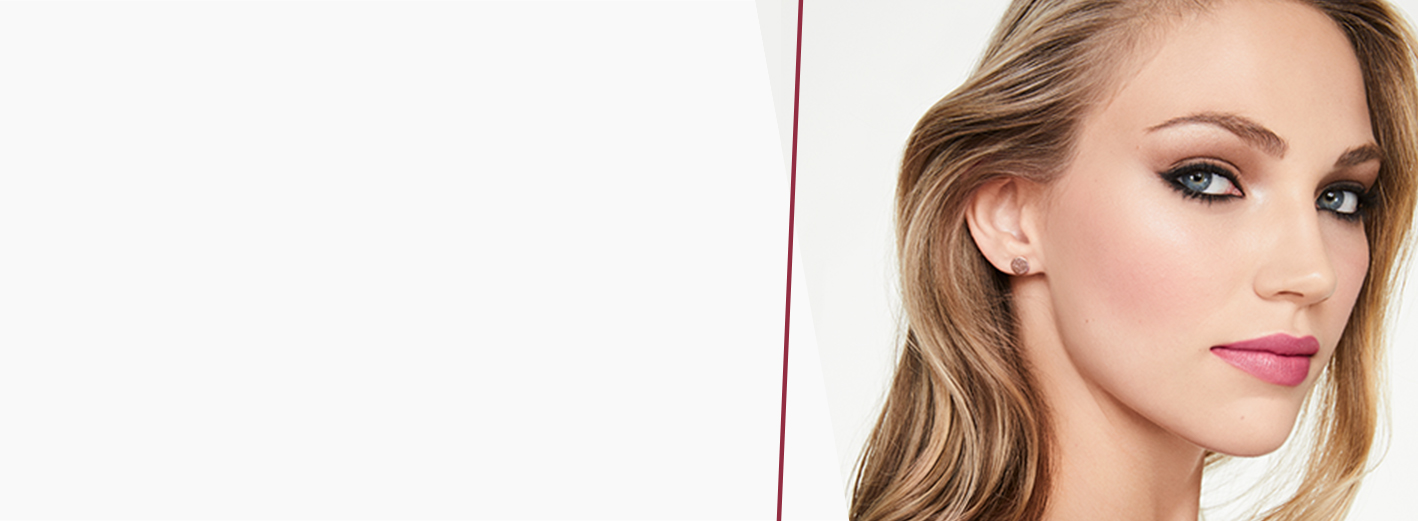 A blonde woman with bold eyeliner and pink lips on a light gray background