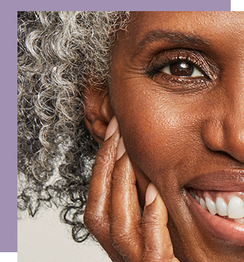 A smiling mature black woman with graying natural hair