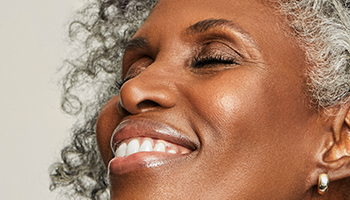 A smiling mature black woman with graying natural hair