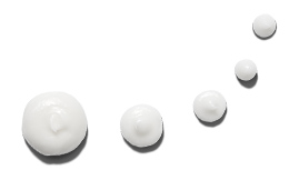 White dots of an opaque skin care cream product lined up in a semicircle shape