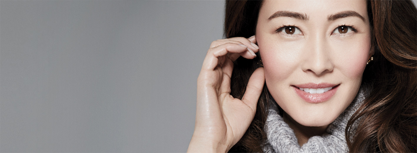 Close-up of model wearing the 5-Minute Holiday Hostess makeup artist look from Mary Kay against a gray background.