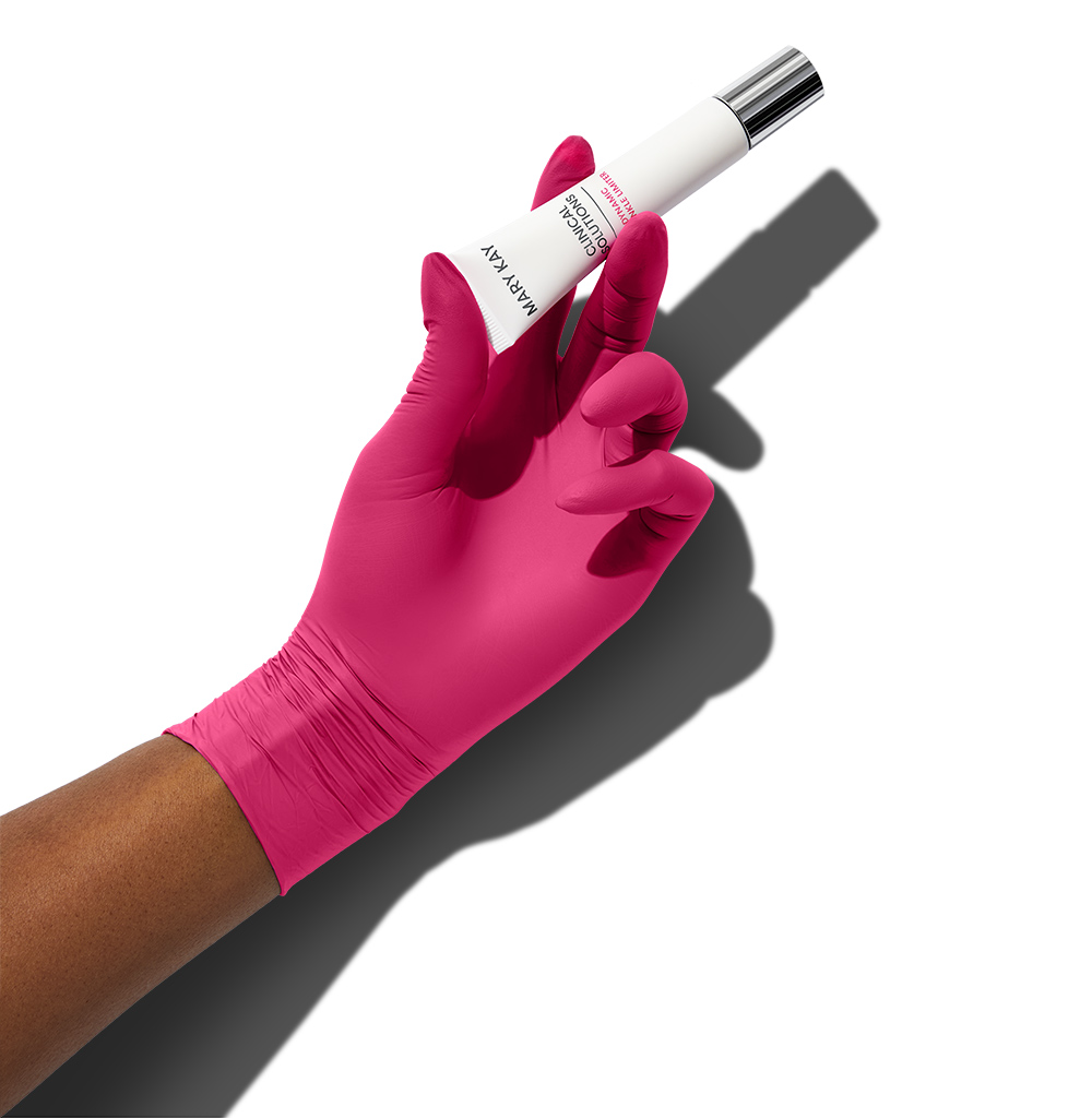 A pink medical gloved hand holding Dynamic Wrinkle Limiter topical cream in the same way one would hold an injection treatment