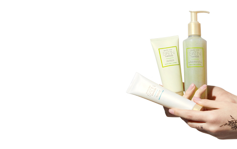 Satin Hands Set in White Tea & Citrus held by a light-skinned hand with a tattoo on a plain white background