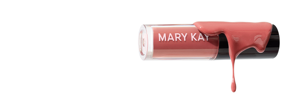 Mary Kay Tinted Lip Oil in Blush laid on its side with cap on and lip oil product spilled on top of it