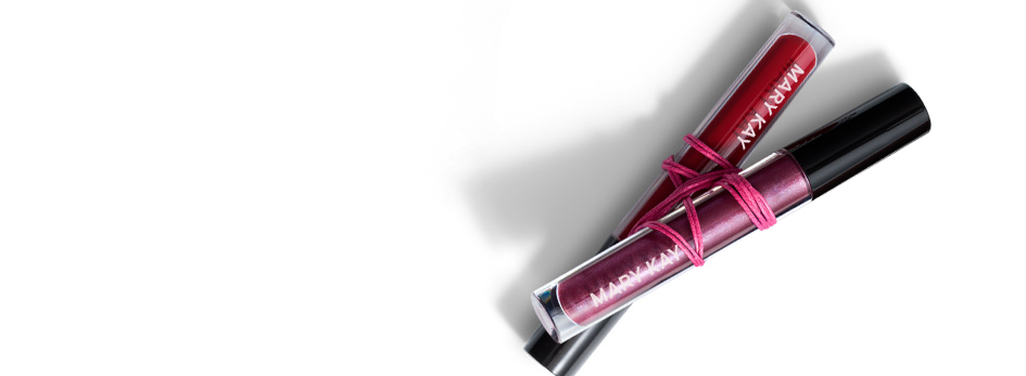 Three limited-edition shades of Mary Kay Unlimited Lip Gloss are bound together with a pink rubber band.